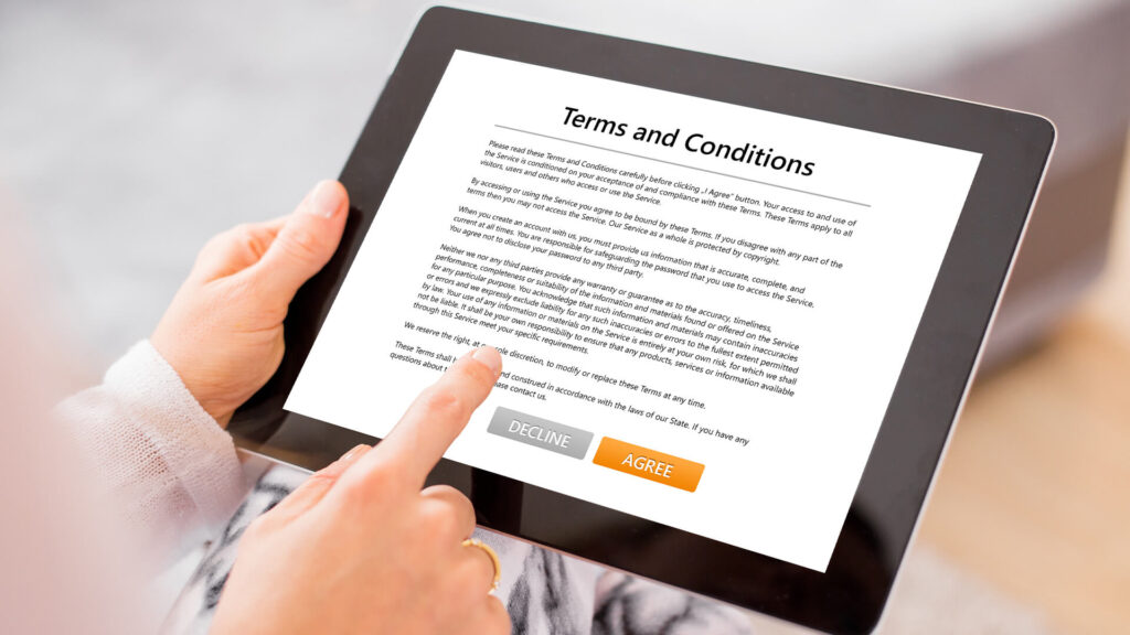 Person reviewing terms and conditions on a tablet with legal consulting guidance before agreeing